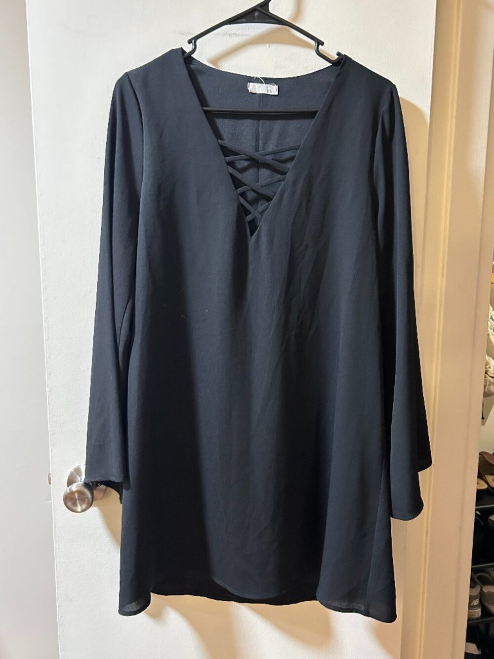 Jella C -- black flowy long sleeve mini dress with criss cross cut out in front